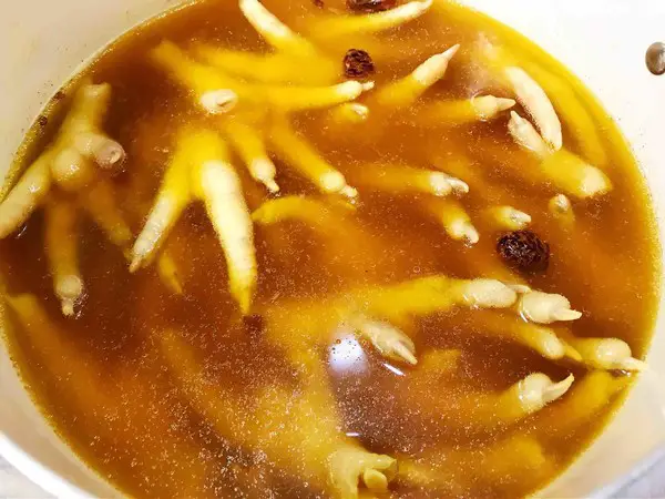 Add the marinated chicken feet and the marinated juice into the pot,