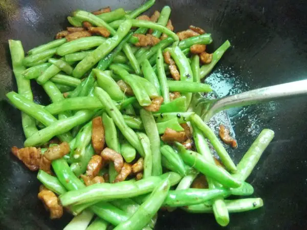 Put the pre-fried four seasons beans into the pork belly